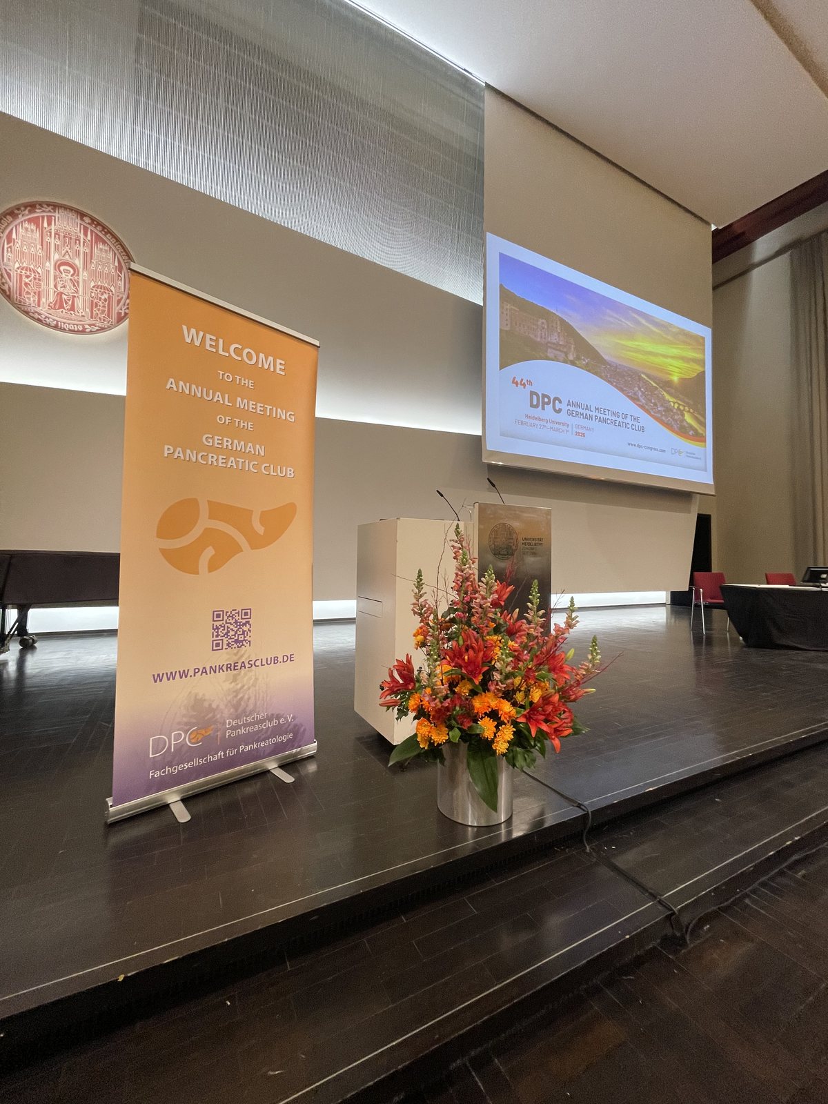 Bühne mit Projektion und floraler Setzung bei einem wissenschaftlichen Kongress