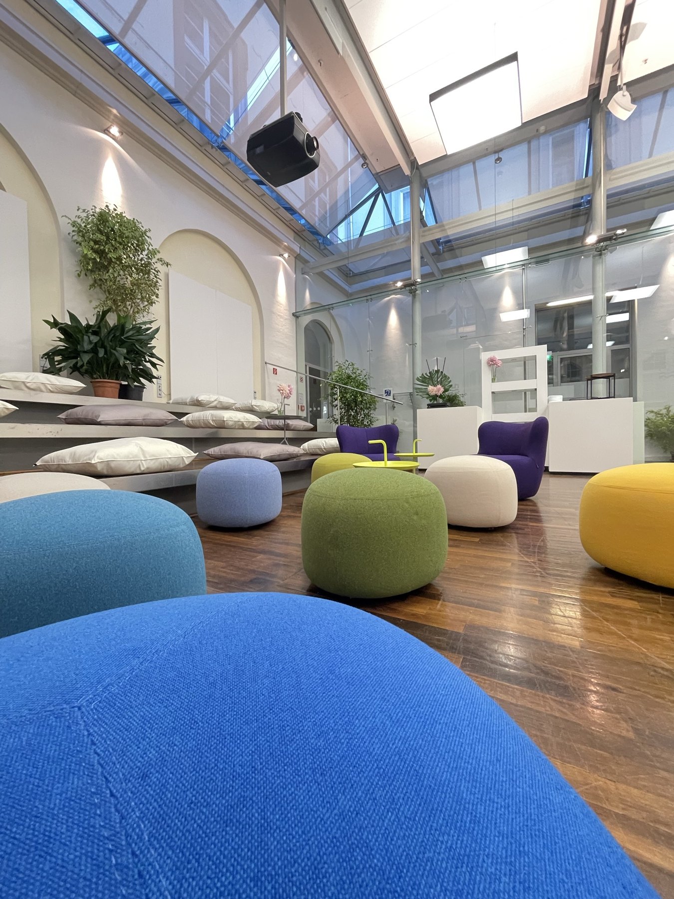 Lounge-Perspektive im Rathaus Heidelberg mit farbigem Mobiliar und Pflanzen